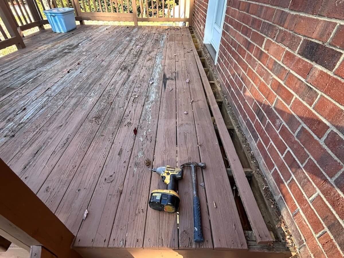 Deck before renovation showing old, worn wood boards